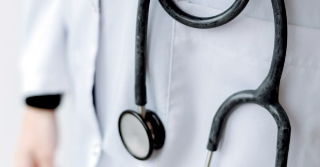 Close-up of a doctor holding a stethoscope, showcasing professional medical attire.