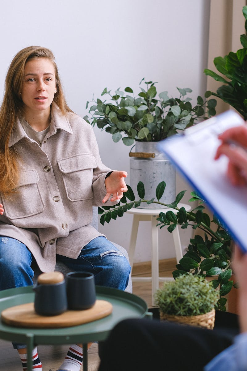 A woman engages in a therapy session, discussing issues with a counselor inside a modern office.